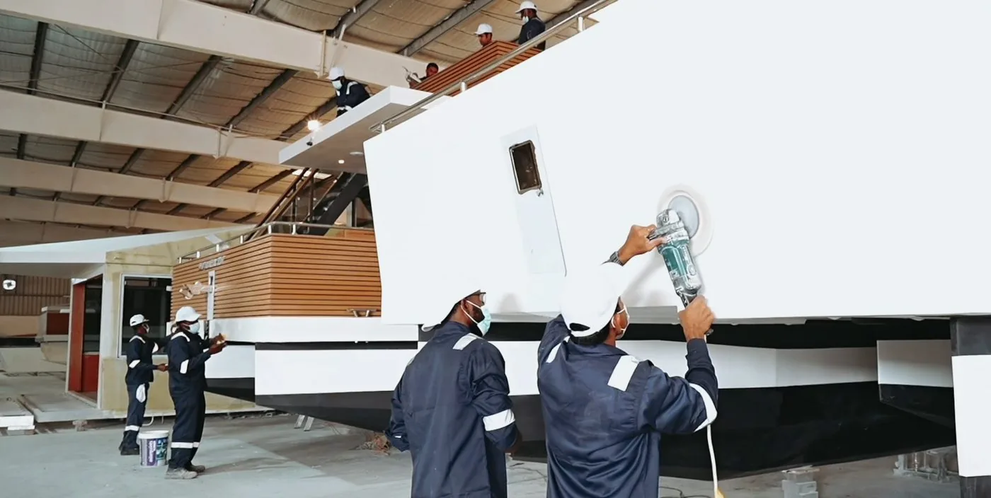 V-Marine technicians finishing a hull inside the Bahrain shipyard
